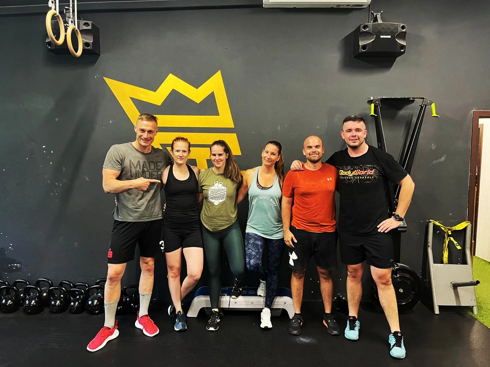 Skupina členov TRIAS Performance Center po spoločnom tréningu pred maľovanou zlatou korunou v gyme